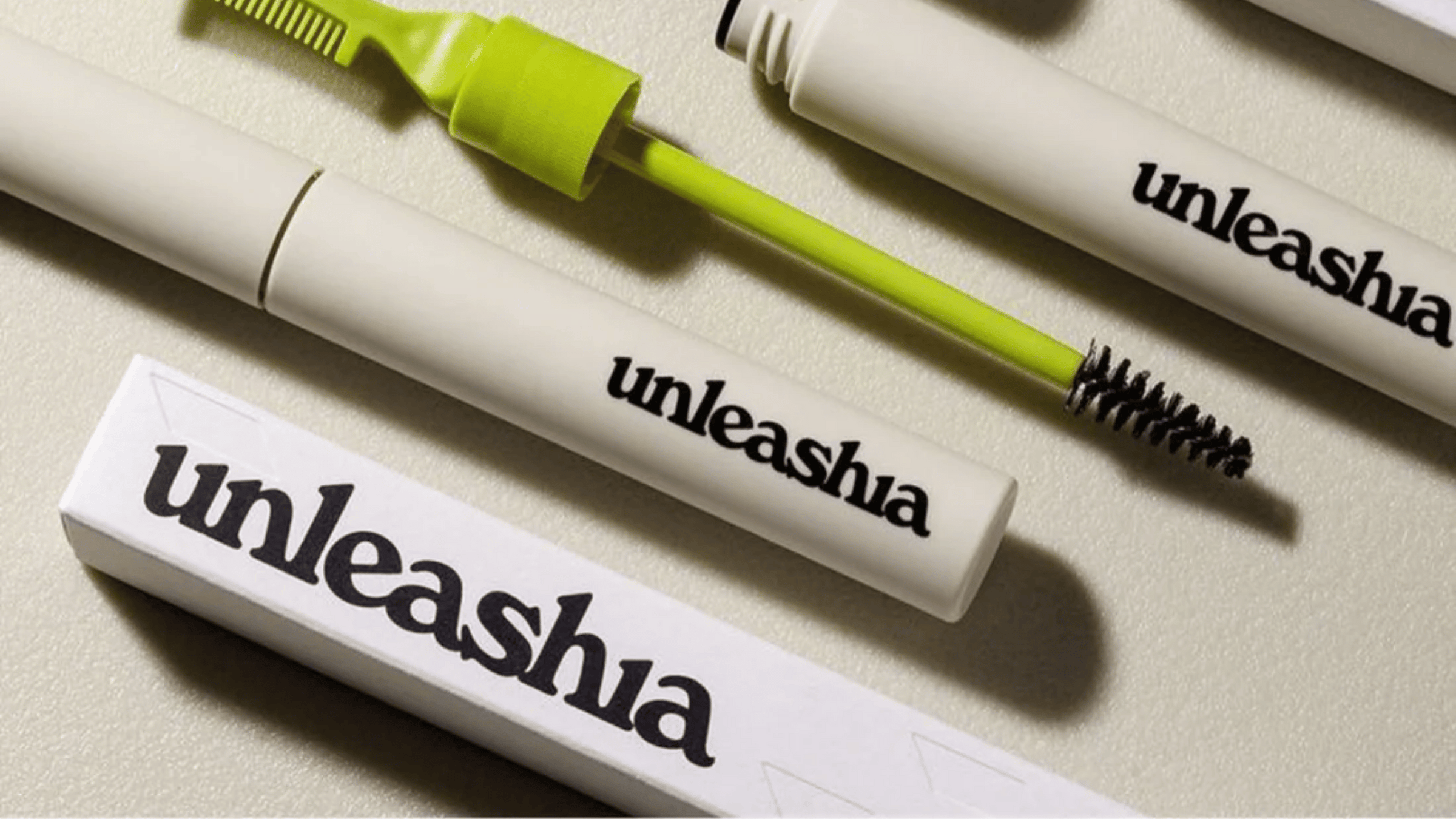 Bilden visar ögonbrynsprodukter från Unleashia med vita förpackningar och svart text. Produkterna, med olika applikatorer, är designade för precision och naturligt formade ögonbryn. Idealiska för enkel användning och hållbara resultat.