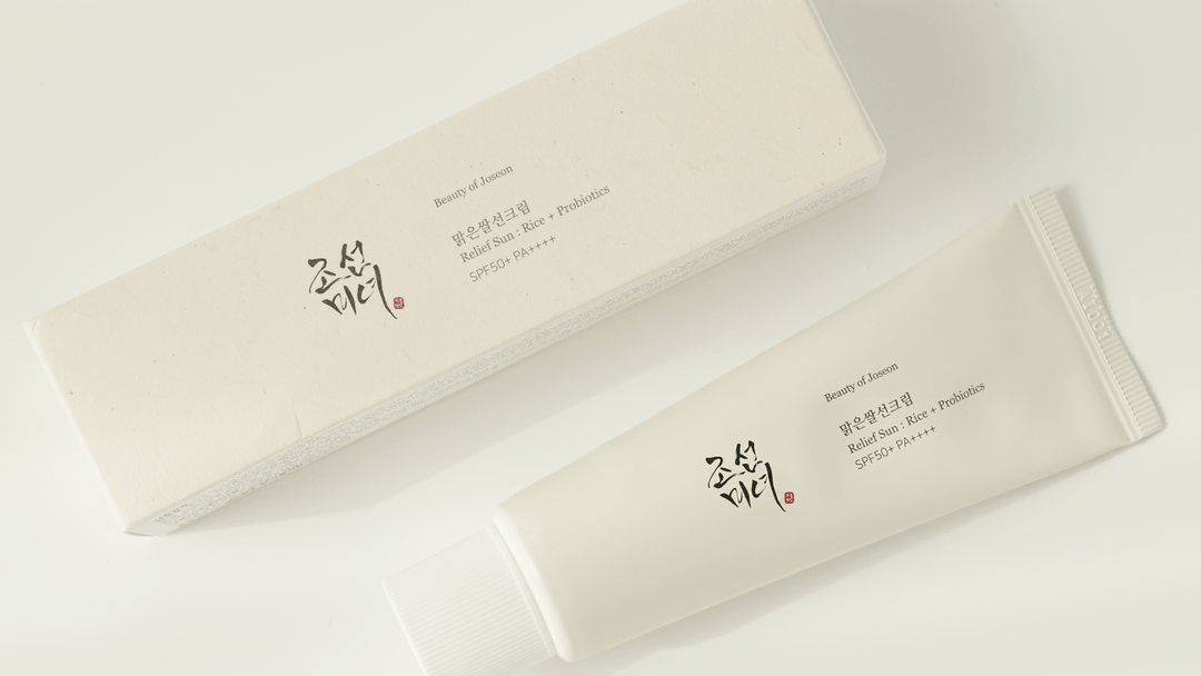 En tub och förpackning av Beauty of Joseon Relief Sun: Rice + Probiotics SPF50+ PA++++ solskyddskräm på en ljus bakgrund.