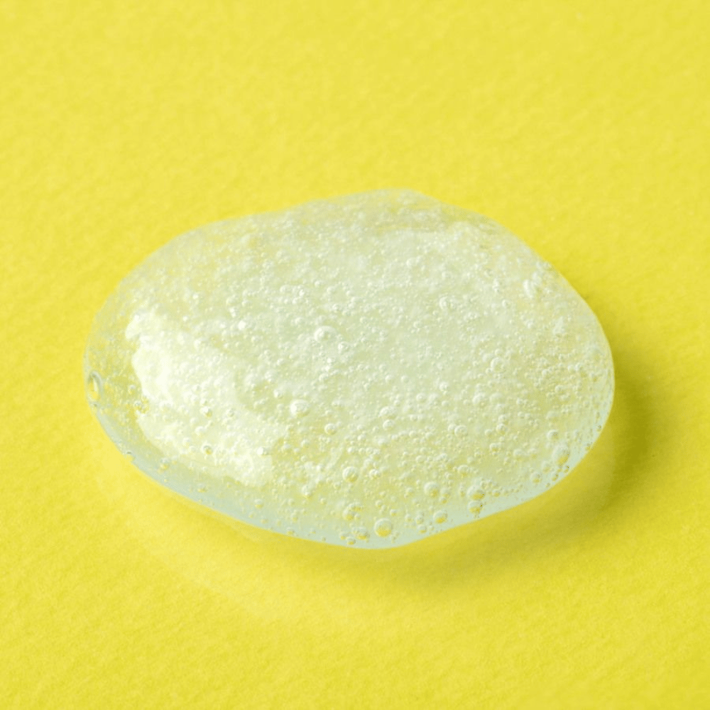 Läpinäkyvä geelitekstuuri COSRX Advanced Snail Mucin Gel Cleanser keltaisella taustalla – kosteuttava kasvojen puhdistus etanaseerumilla pehmeälle ja tasapainoiselle iholle.