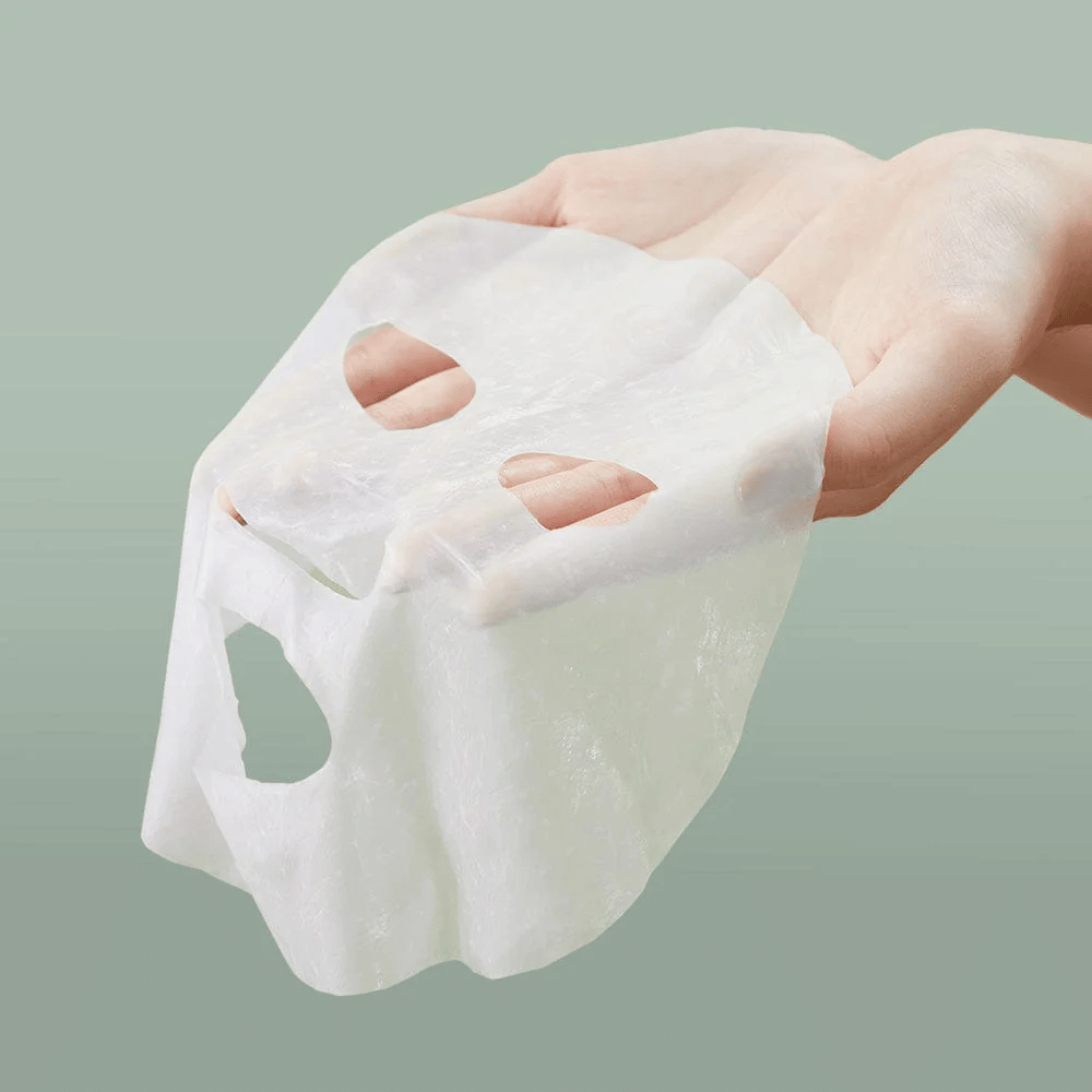 Henkilön käsi, joka pitää Anua Heartleaf 77% Soothing Sheet Mask.