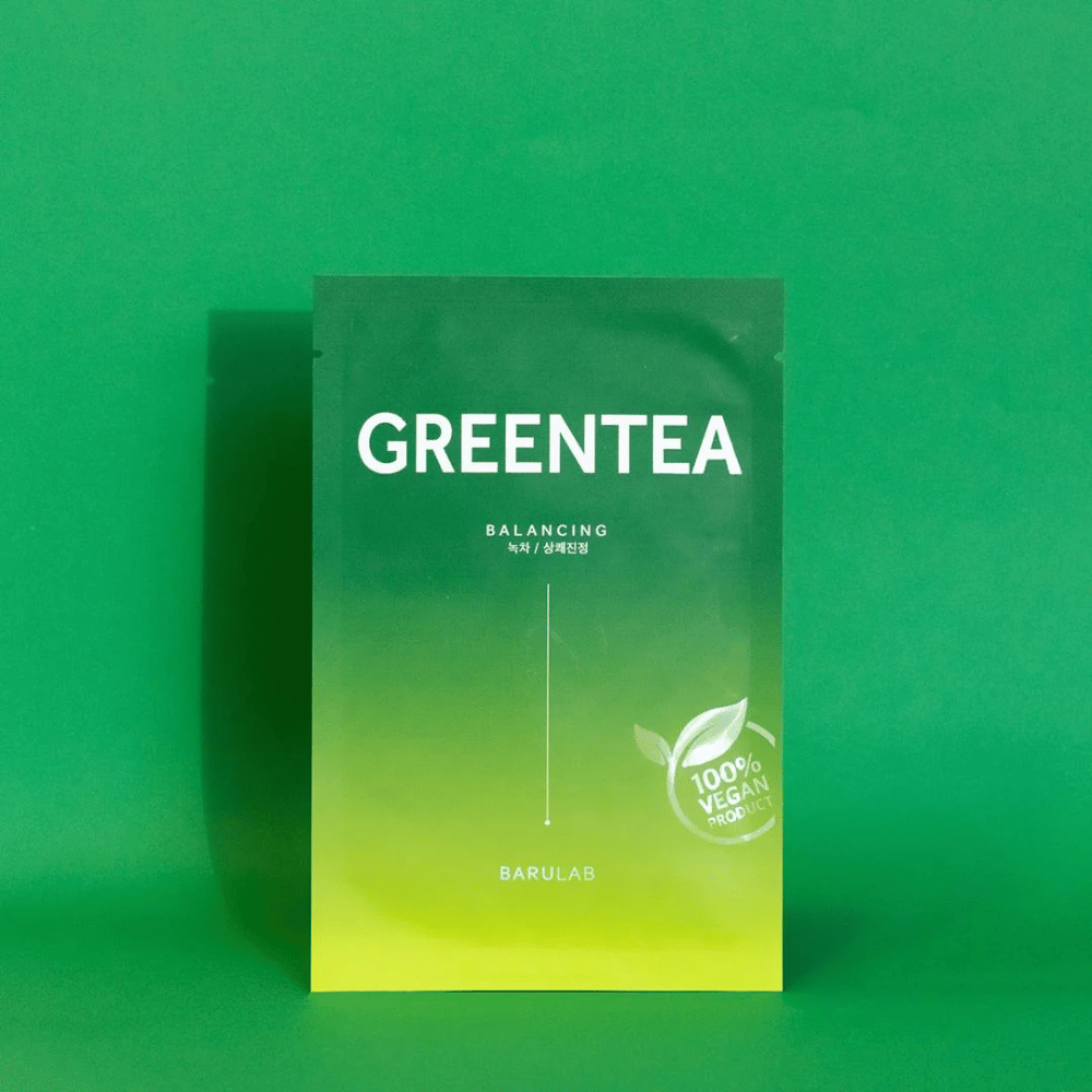 Pakkaus BARULAB "GREENTEA Balancing" -maskille, merkitty "100% Vegan Product". Pakkauksen väri muuttuu tummanvihreästä ylhäältä vaaleampaan vihreään alhaalla, yhtenäisellä vihreällä taustalla.