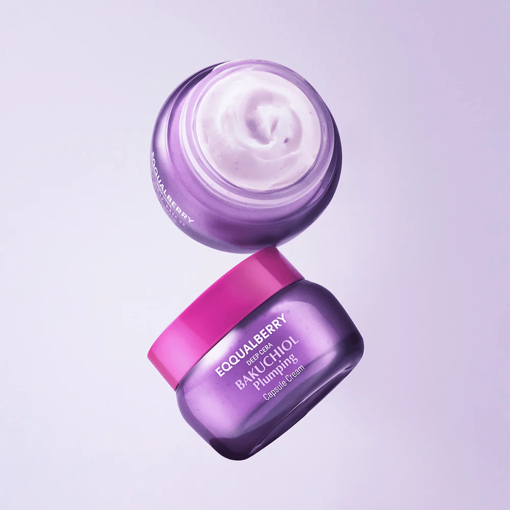 Kaksi avointa purkkia EQQUALBERRY Bakuchiol Plumping Capsule Cream purppuraisessa pakkauksessa vaaleanpunaisella kannella. Voiteen pehmeä koostumus näkyy selvästi ylhäältä päin.