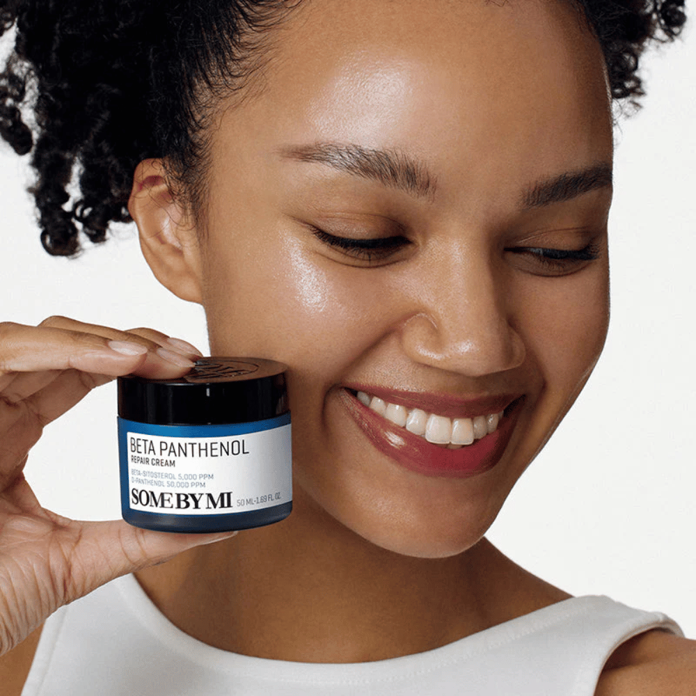 Malli hehkuvalla iholla pitää kädessään SOME BY MI Beta Panthenol Repair Cream – korealainen kasvovoide, joka vahvistaa ihon suojakerrosta ja kosteuttaa.