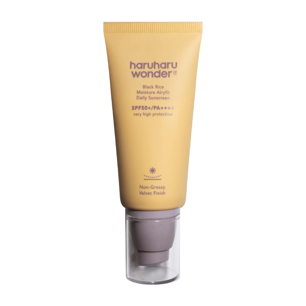 Keltainen tuubi, jossa on Haruharu Wonder Black Rice Moisture Airyfit Daily Sunscreen SPF 50+ PA++++. Tuubissa on läpinäkyvä korkki ja teksti, joka kuvailee aurinkovoiteen korkeaa suojatasoa sekä sen rasvatonta, samettista lopputulosta.