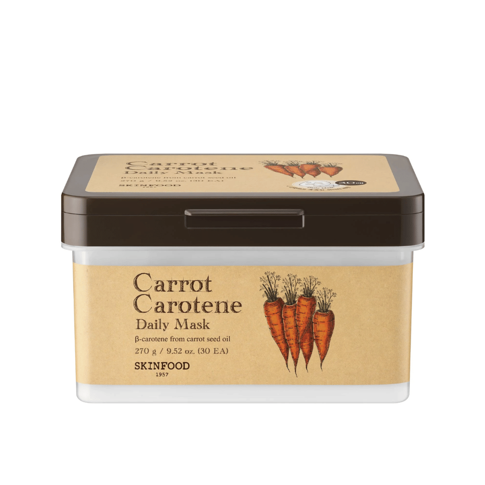 Pakkaus "Carrot Carotene Daily Mask" SKINFOOD:stä, joka sisältää 30 kasvonaamiota. Tuote on rikastettu porkkanansiemenöljystä saadulla β-karoteenilla ja suunniteltu päivittäiseen käyttöön. Pakkaus on kestävä ja siinä on vintage-henkinen etiketti, joka korostaa porkkanoita pääainesosana.