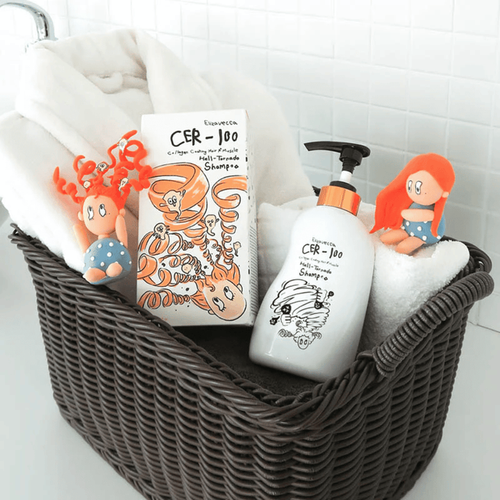 Esittelykuva, jossa Elizavecca CER-100 Shampoo ja tuotepakkaus on sijoitettu koriin yhdessä pyyhkeiden kanssa. Pakkauksen suunnittelusta tutut leikkisät hahmot korostavat brändin ainutlaatuista ja luovaa tyyliä.