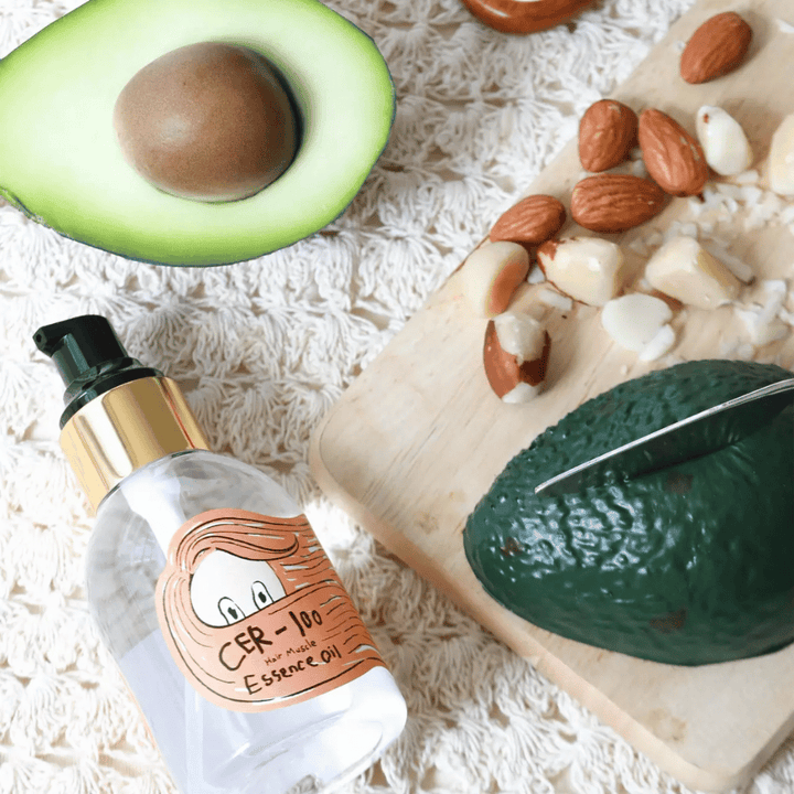 Elizavecca CER-100 Hair Muscle Essence Oil ainesosat – lähikuva avokadosta ja kasviöljyistä, joka esittelee ravitsevan hiusöljyn, joka auttaa pehmentämään ja hoitamaan hiuksia.