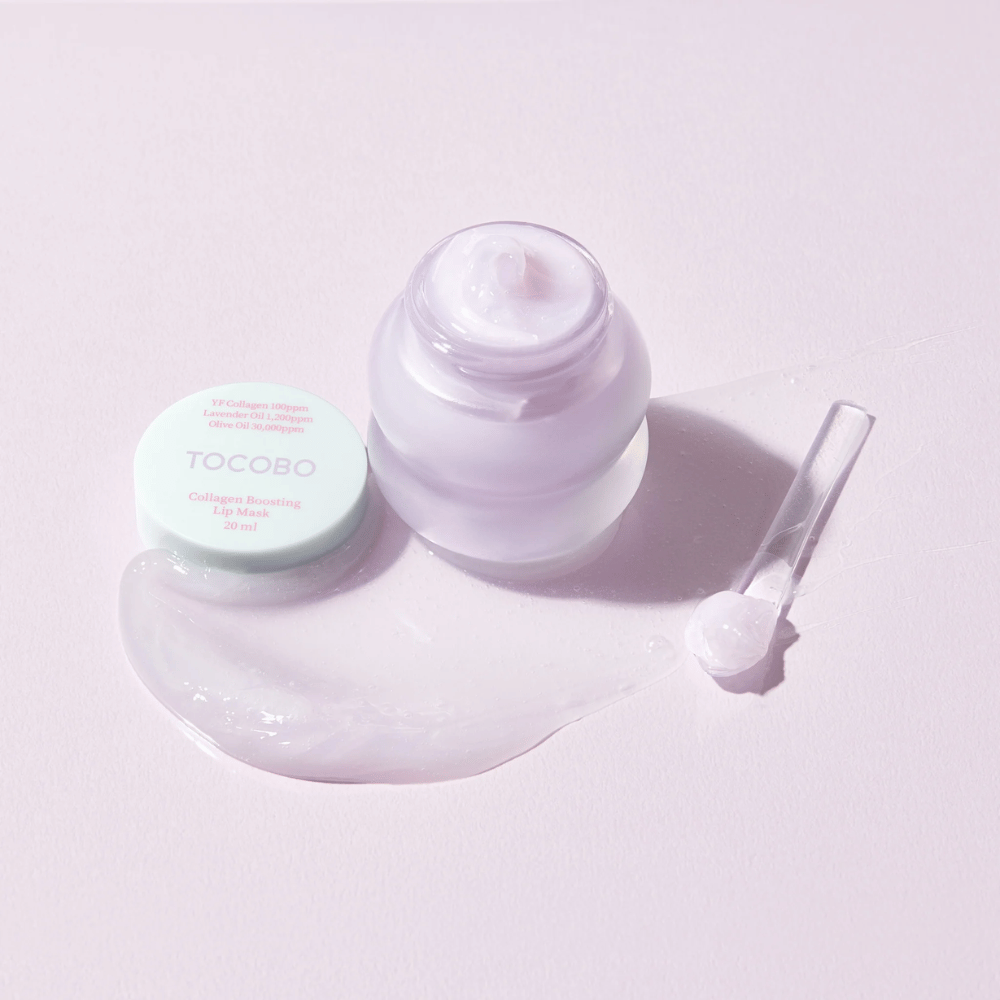 Avoin purkki TOCOBO Collagen Boosting Lip Mask lastalla ja levitettyä lilaa voidetta vaaleanlilalla taustalla.
