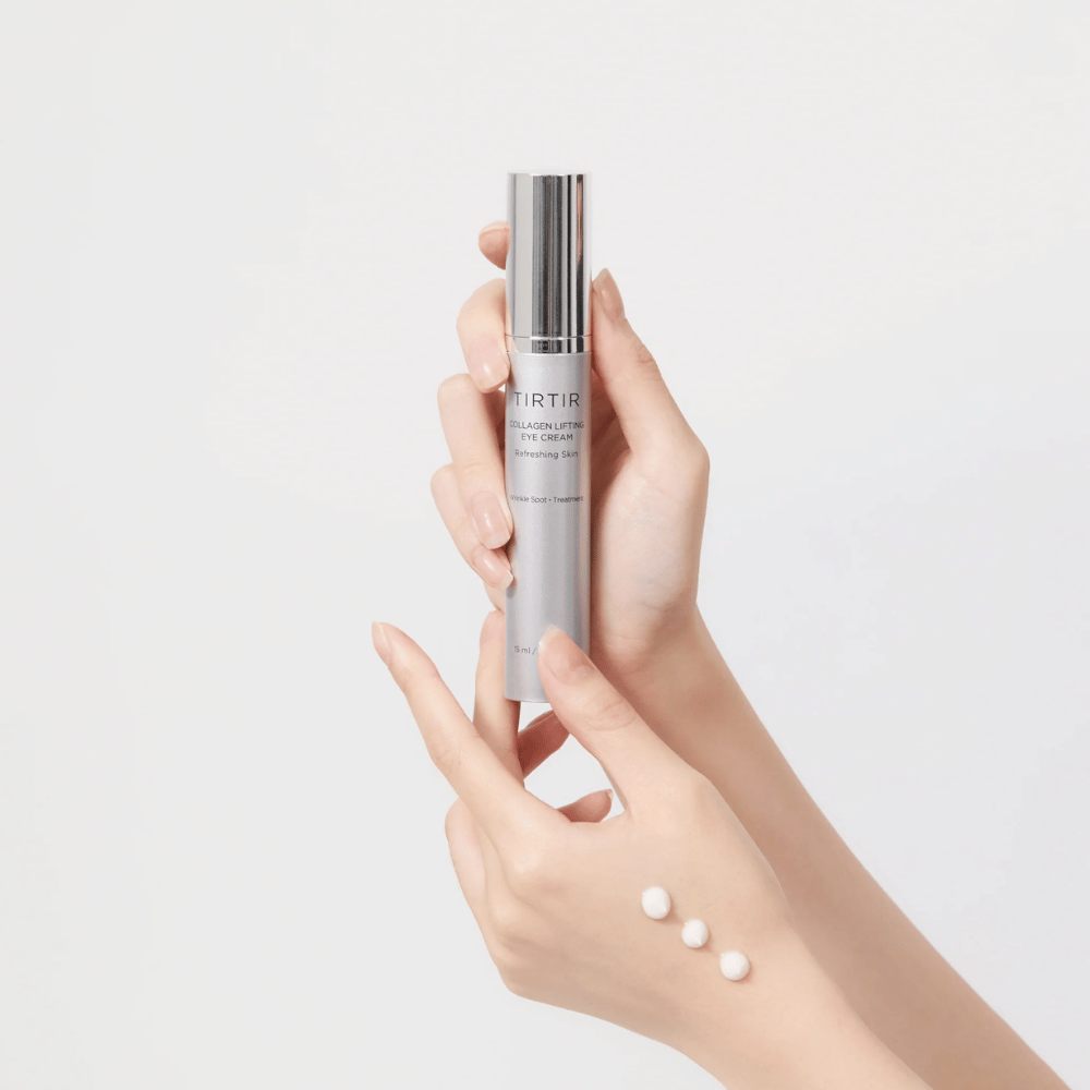 Kädet pitävät tuubia, jossa on TIRTIR Collagen Lifting Eye Cream, tuotetta puristettuna kädenselälle.