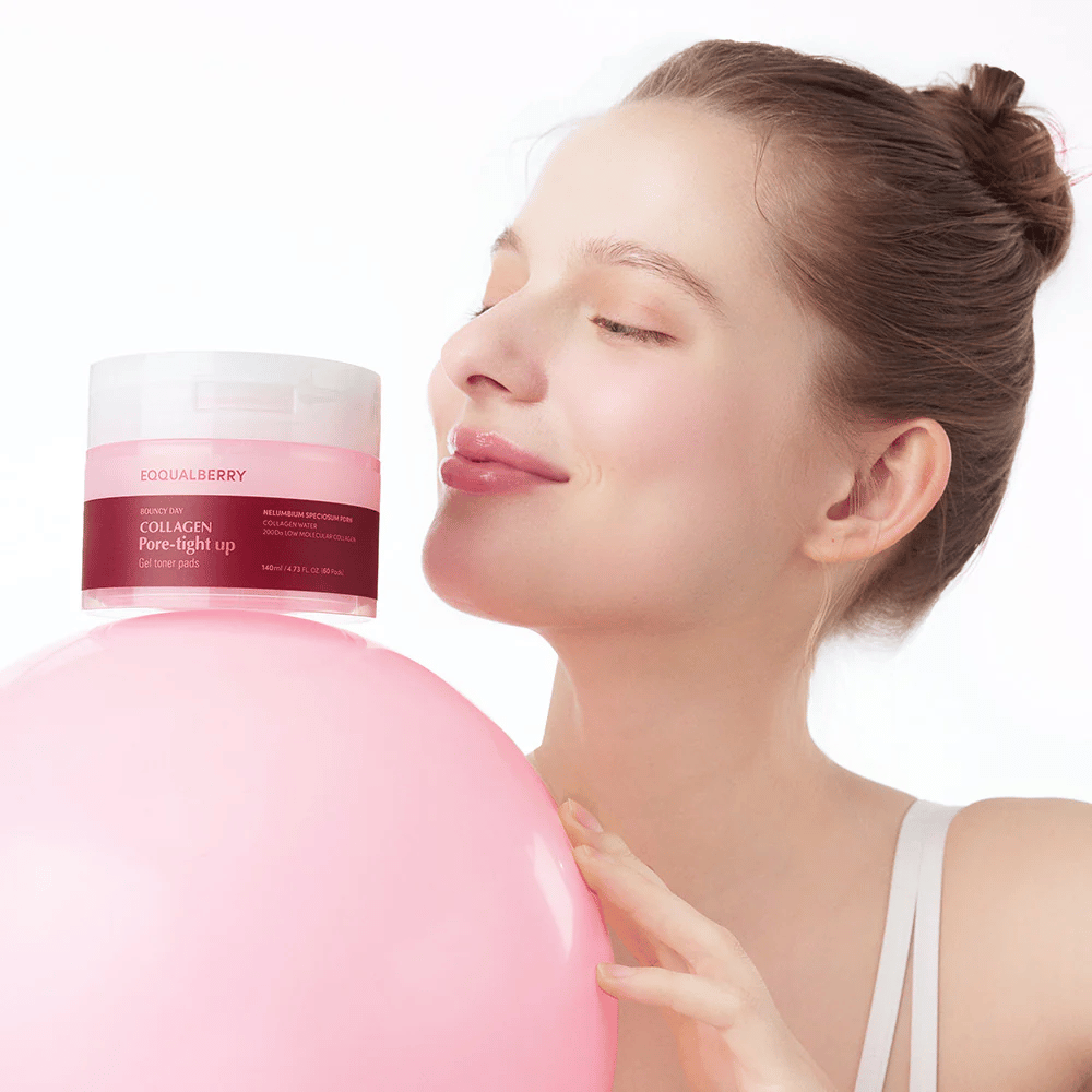 Nainen seisoo vaaleanpunaisen pallon ja purkin Collagen Pore-Tight Up Gel Toner Pads kanssa, samalla kun hän hymyilee ja pitää purkkia lähellä kasvojaan. Purkki on merkitty tuotteen nimellä ja sisältää kasvovesityynyjä, jotka auttavat kiinteyttämään ihoa ja pienentämään huokoskokoa.