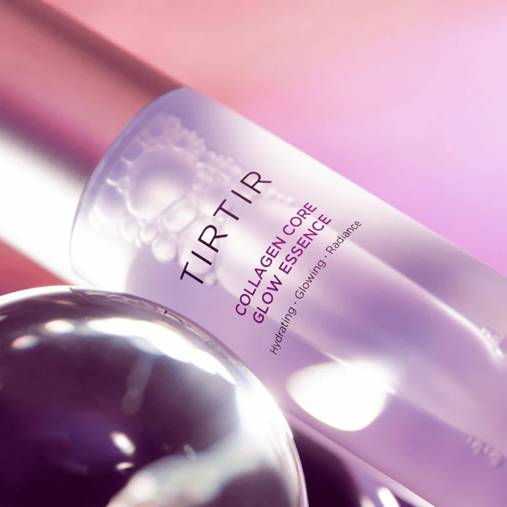 Lähikuva TIRTIR Collagen Core Glow Essence – hehkua antava essence elegantissa violetissa pullossa, keskittyen kosteutukseen ja ihon luonnolliseen hehkuun.