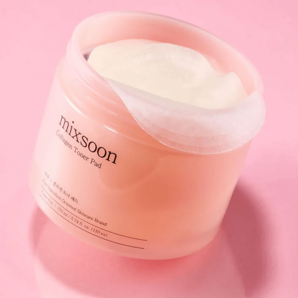 Mixsoon Collagen Toner Pad 110 tyynyllä vaaleanpunaisessa purkissa, valokuvattu vaaleanpunaista taustaa vasten.