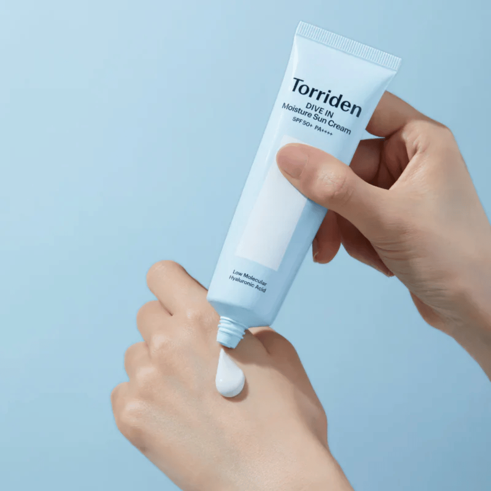 Torriden DIVE-IN Moisture Sun Cream SPF50+ PA++++ levitetään kädelle, jotta kosteuttavan aurinkovoiteen kevyt ja voidemainen koostumus tulee esiin.