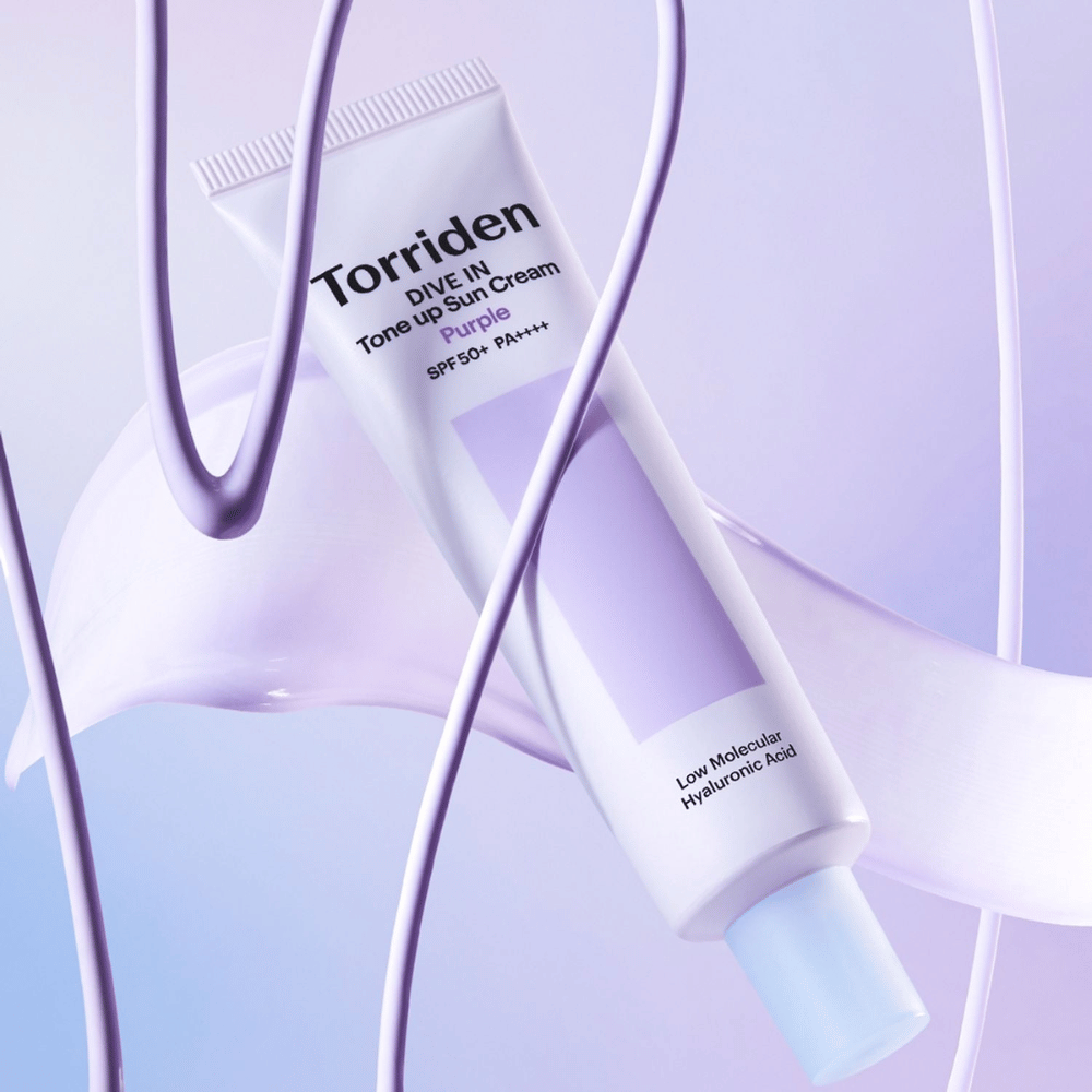 Torriden DIVE IN Tone Up Sun Cream Purple SPF50+ PA++++ esitelty luovassa tuoteasetelmassa violetein yksityiskohdin, jotka korostavat kosteuttavaa koostumusta.