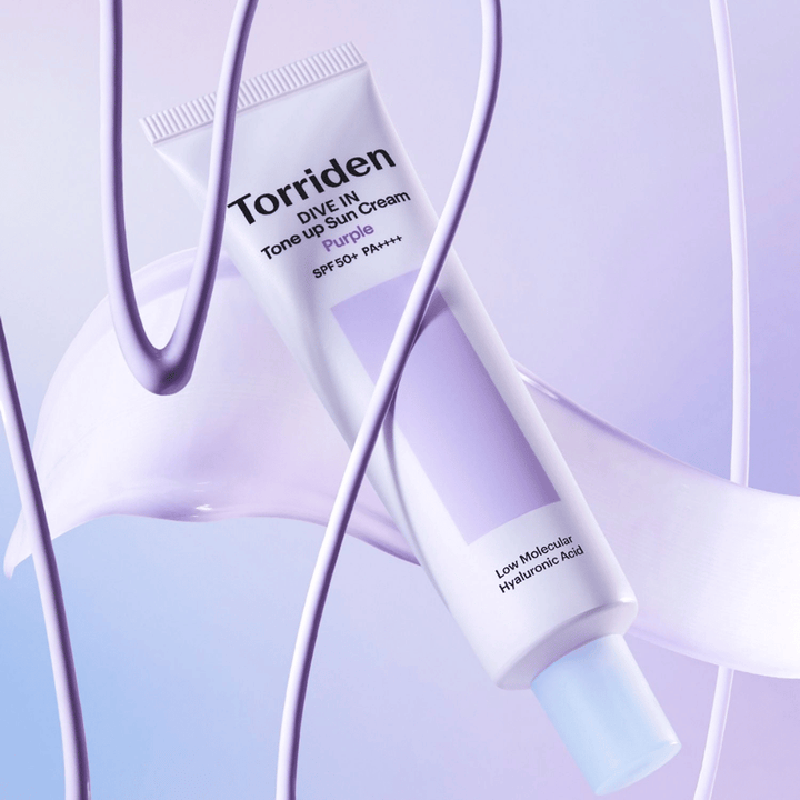 Torriden DIVE IN Tone Up Sun Cream Purple SPF50+ PA++++ esitelty luovassa tuoteasetelmassa violetein yksityiskohdin, jotka korostavat kosteuttavaa koostumusta.