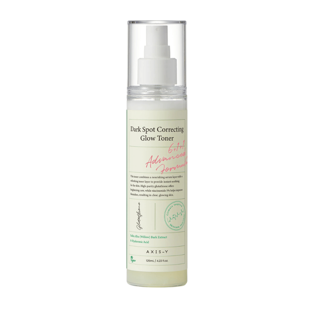 Kuva tuotteesta "AXIS-Y Dark Spot Correcting Glow Toner" -pullo. Pullo on läpinäkyvä, siinä on valkoinen etiketti ja musta-vihreä teksti. Tuote on suihkutettava kasvovesi, ja pullo sisältää 125 ml (4,23 fl. oz). Etiketissä mainitaan avainainesosat kuten pajunkuoriuute ja hyaluronihappo.