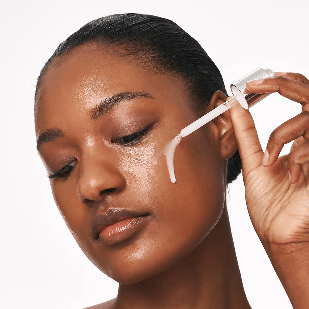 Henkilö levittää Deep Collagen Power Boosting Cream in Serum poskelle pipetillä. Seerumi tekee ihosta kiinteämmän, kosteutetun ja hehkuvan.