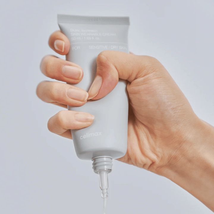 Käsi levittää Celimax Dual Barrier Skin Wearable Cream, suojamuuria vahvistava kasvovoide herkälle ja kuivalle iholle, joka tarjoaa pitkäkestoista kosteutusta ja suojaa ihon suojamuuria.