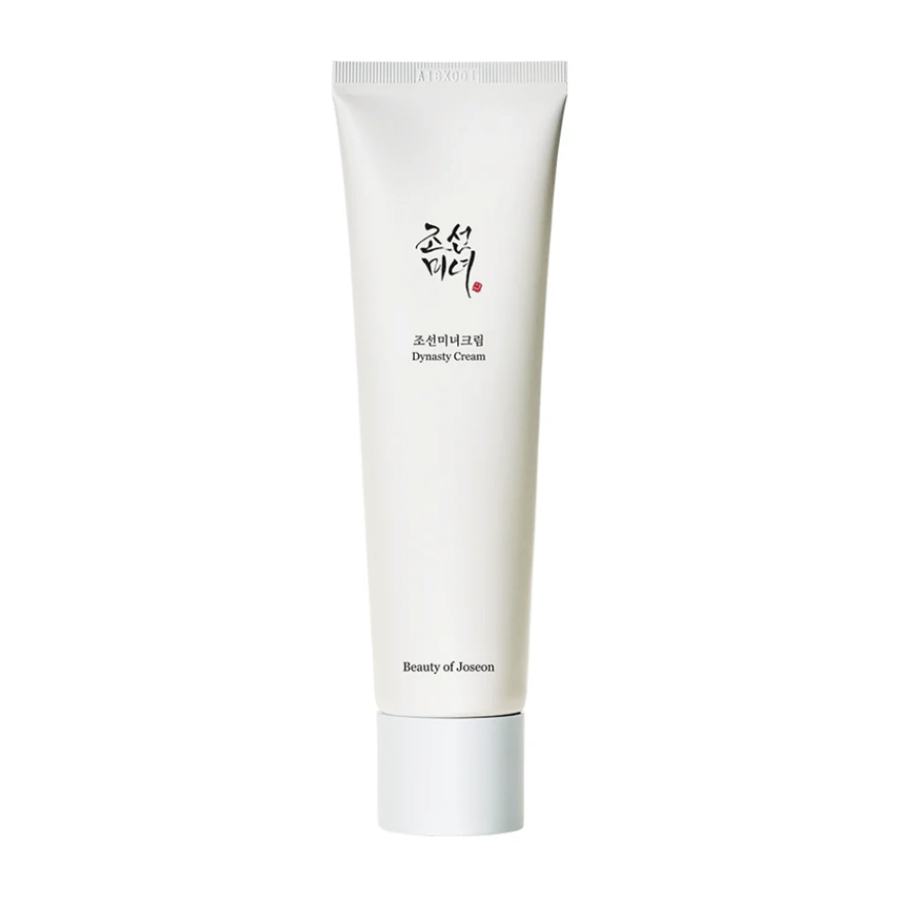Kuva näyttää "Beauty of Joseon Dynasty Cream" -tuubin. Hoikka, valkoinen tuubi sisältää minimalistisia suunnitteluelementtejä, mukaan lukien tyylikäs musta ja punainen teksti. Tämä ihonhoitotuote lupaa ravita ja elvyttää ihoa, heijastaen Joseon-dynastian aikaisia kauneussalaisuuksia.
