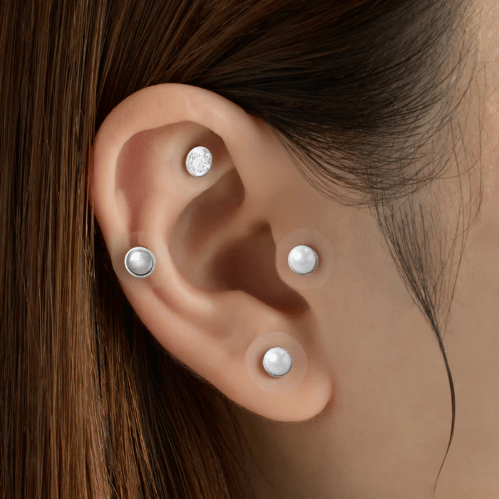 Lähikuva korvasta, jossa on useita RETURNITY Ear Therapy Acupressure Patch kiinnitettynä korvan eri alueille akupainantaa ja tyylikästä ilmettä varten.