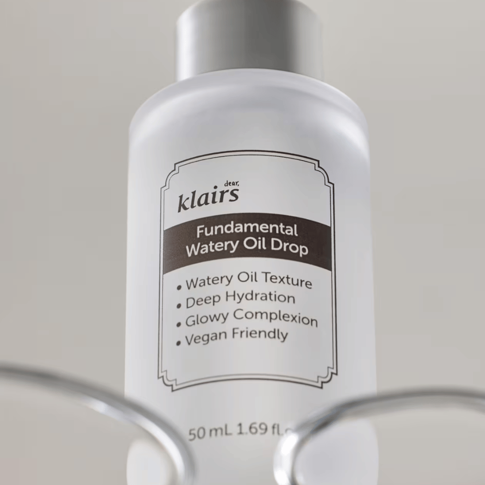 Pullo, jossa on Klairs Fundamental Watery Oil Drop, 50 ml, sijoitettuna läpinäkyvään pidikkeeseen, selkeällä etiketillä, joka korostaa tuotteen kosteuttavia ja vegaanisia ominaisuuksia.