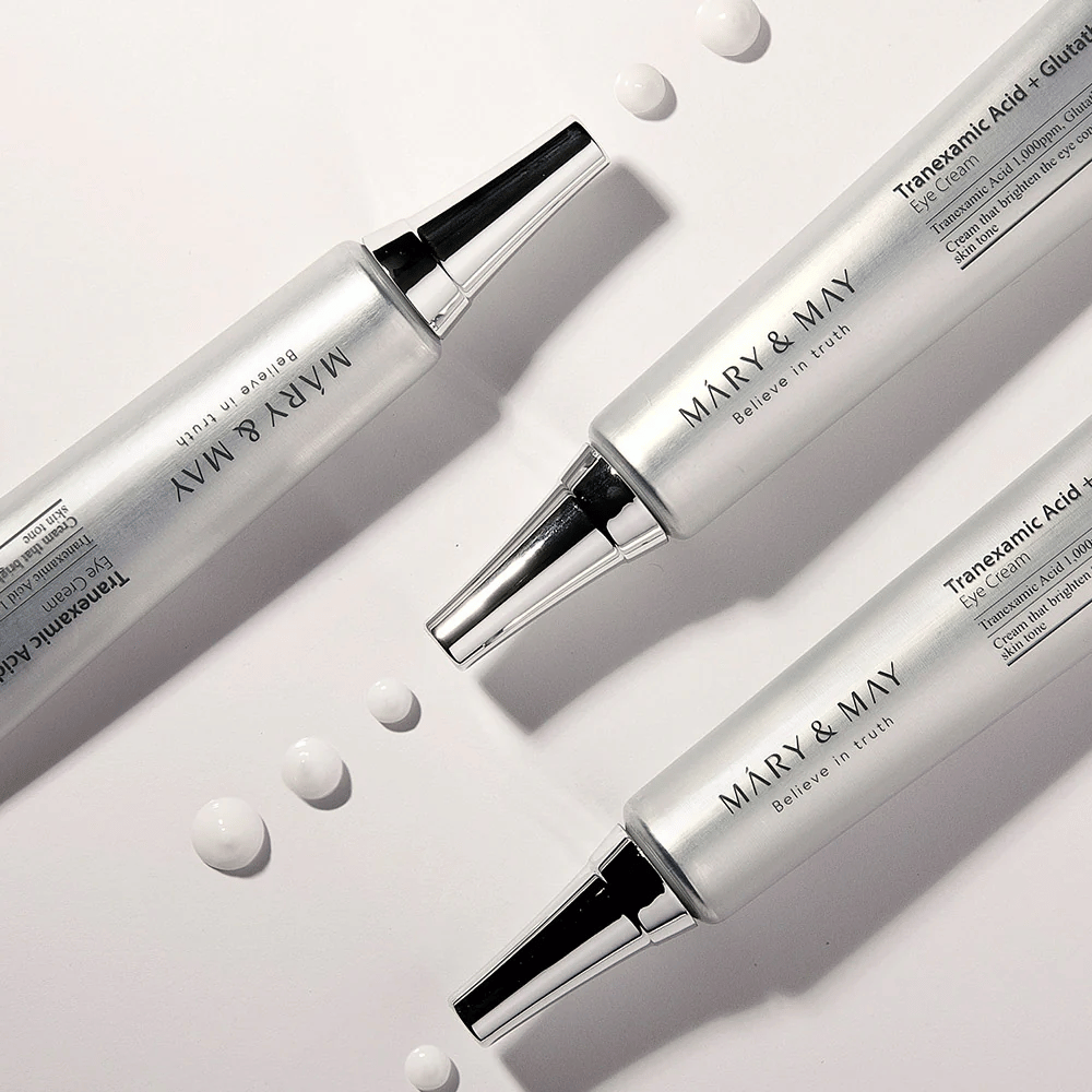 Stailattu tuotekuva Mary&May Tranexamic Acid + Glutathione Eye Cream, joka näyttää voiteen koostumuksen ja keskittyy kirkastavaan silmänympäryshoitoon.