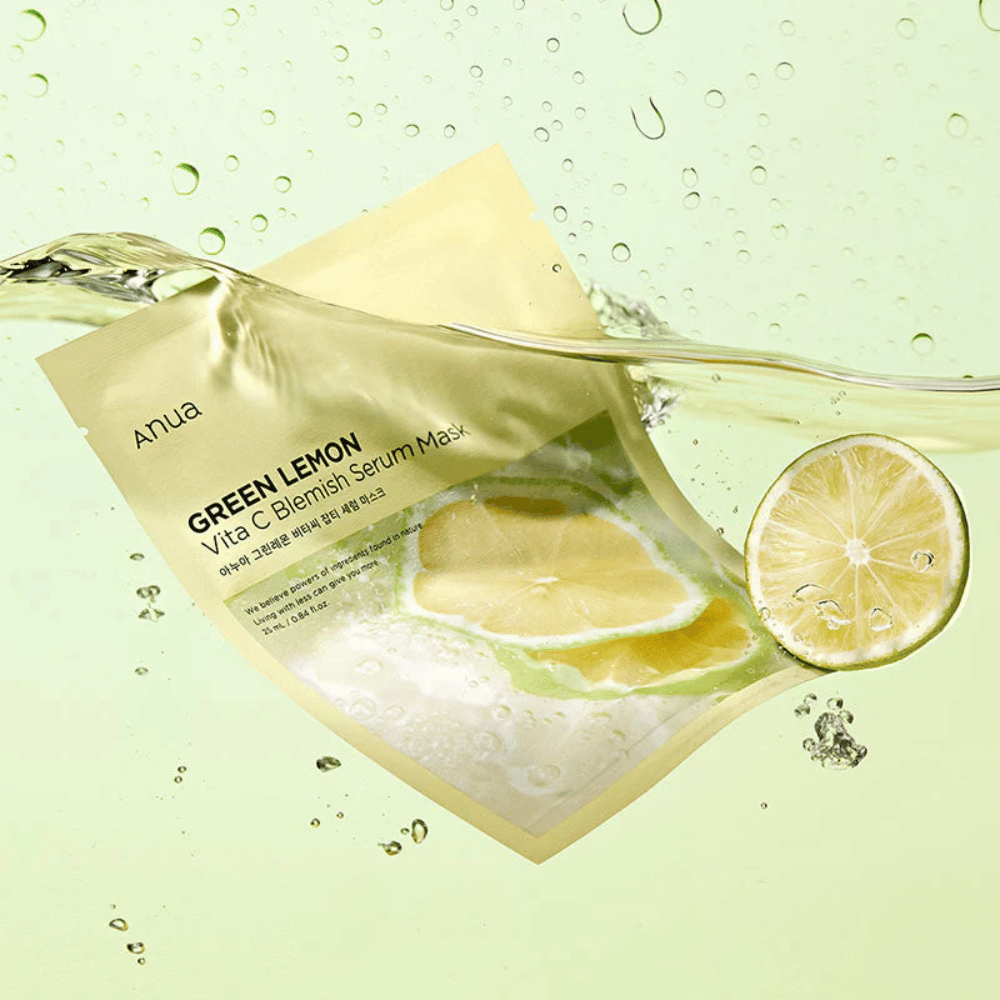 Elävä kuva Anua Green Lemon Vita C Blemish Serum Mask pakkauksesta läpinäkyvillä vesipisaroilla ja vihreän sitruunan viipaleilla ympärillä. Pakkaus on osittain peitetty veden virralla vaaleanvihreällä taustalla.