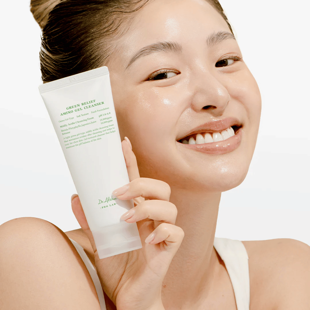 Nainen, jolla on säteilevä iho, pitää esillä Dr. Althea Green Relief Amino Gel Cleanser – vegaaninen puhdistus herkälle ja ärtyneelle iholle.