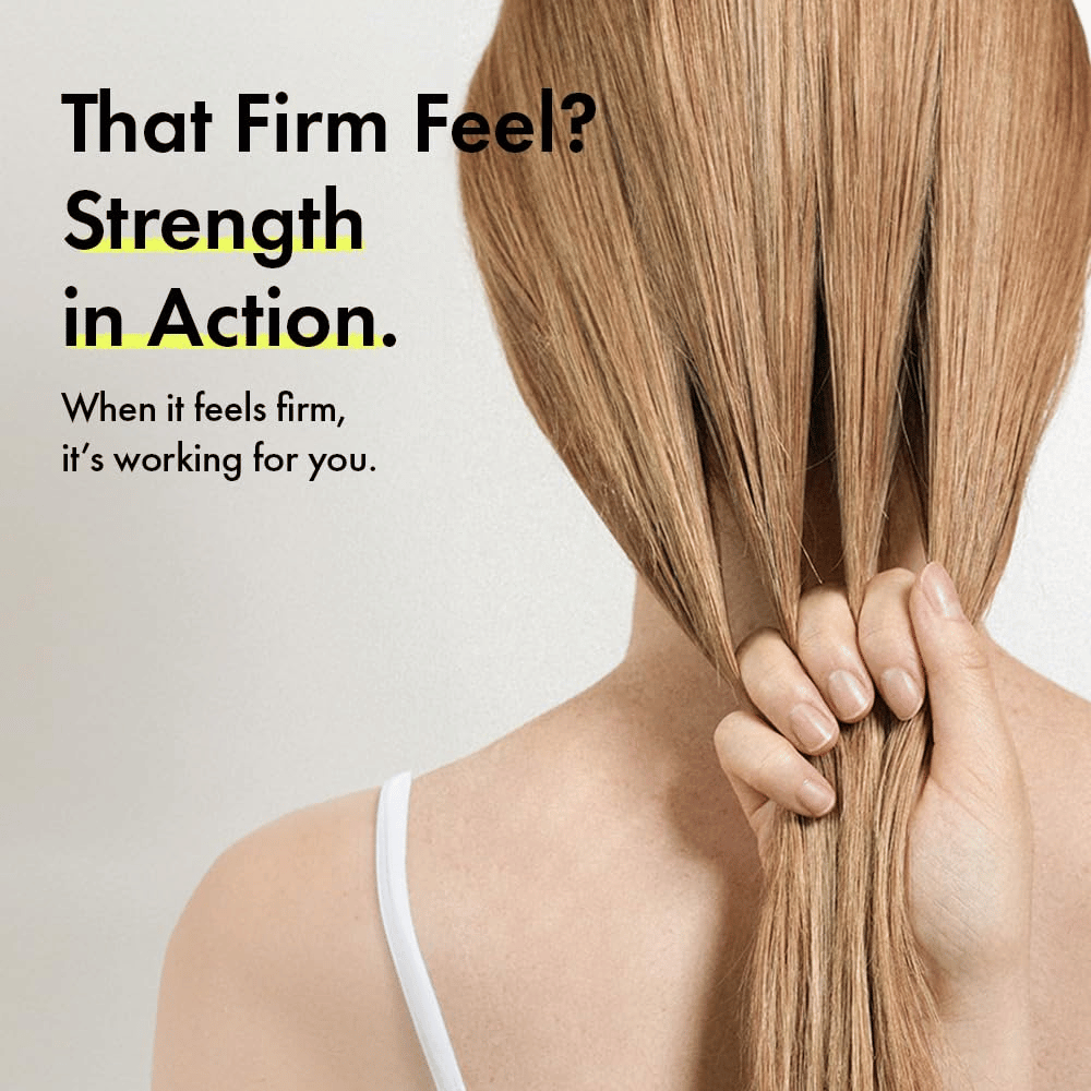 Henkilö pitelee hiuksiaan havainnollistaakseen vahvempia hiussuortia ja napakampaa hiustuntumaa Grabity g0.0 Hair Lifting Shampoo Strong -tuotteen käytön jälkeen.