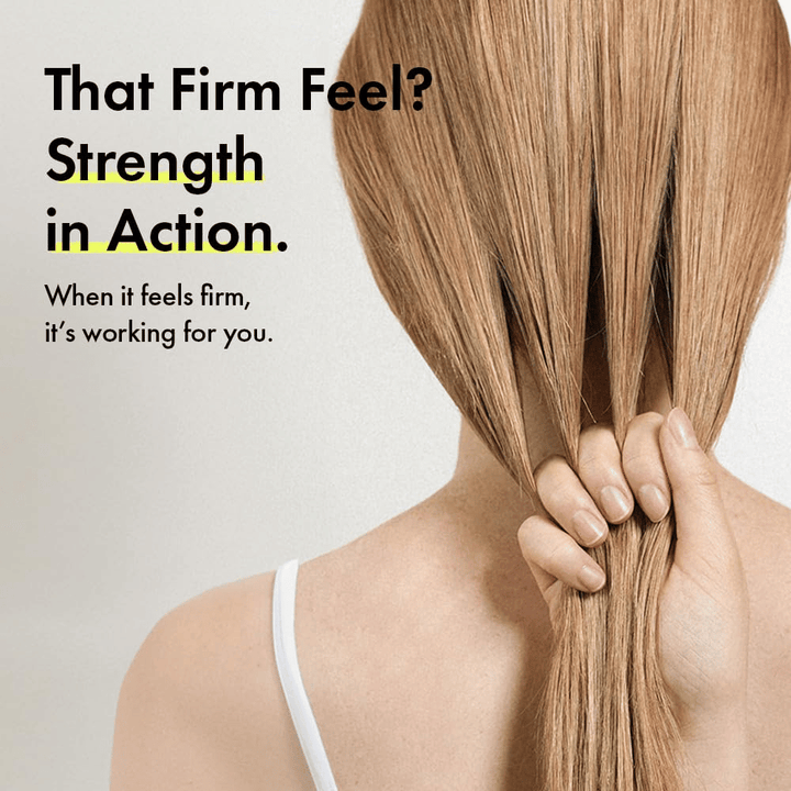 Henkilö pitelee hiuksiaan havainnollistaakseen vahvempia hiussuortia ja napakampaa hiustuntumaa Grabity g0.0 Hair Lifting Shampoo Strong -tuotteen käytön jälkeen.