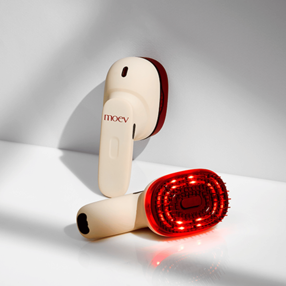 Kaksi MOEV Hair Steamer Prota valkoisella taustalla. Yksi näyttää aktivoidut punaiset LED-valot, jotka stimuloivat hiuspohjaa ja parantavat hiustenkasvua.