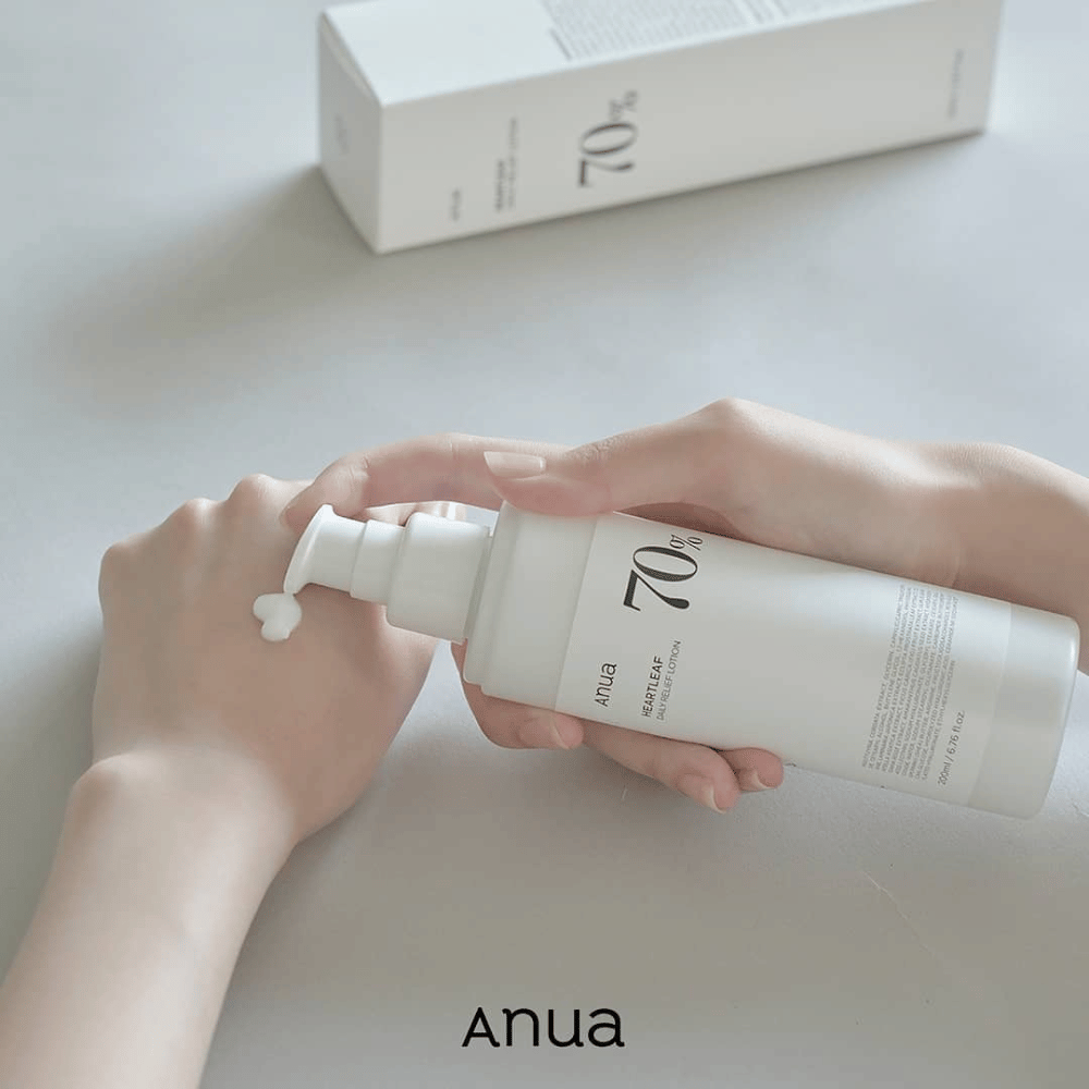 Henkilö pitää kädessään pulloa Anua Heartleaf 70% Daily Lotion 200ml.