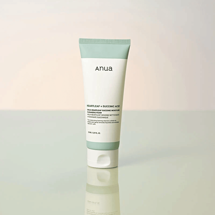 Erillinen tuotekuva tuotteesta Anua Heartleaf + Succinic Acid Moisture Cleansing Foam. Tuote on esitetty seisomassa heijastavalla pinnalla, mikä tuo selkeästi esiin pakkauksen muotoilun ja brändin tyylikkään estetiikan.