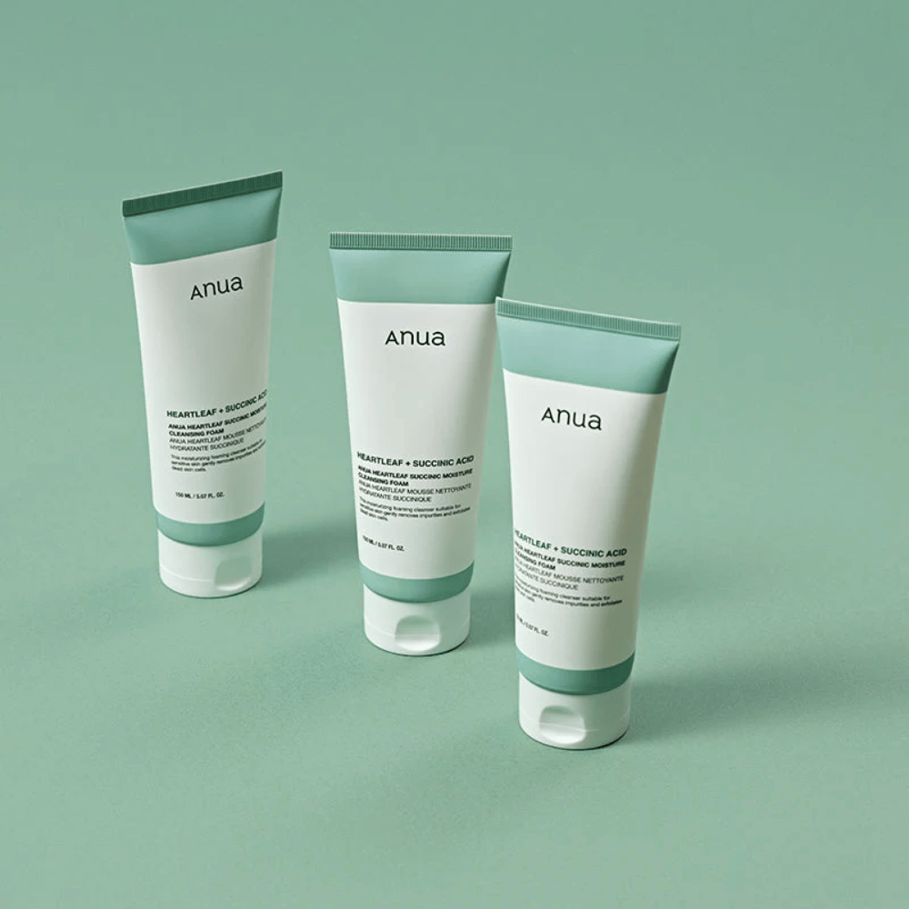 Kolme pakkausta Anua Heartleaf + Succinic Acid Moisture Cleansing Foam -tuotetta esiteltynä vaaleanvihreää taustaa vasten. Kuva korostaa tuotteen puhdasta ja minimalistista muotoilua sekä antaa ammattimaisen vaikutelman tuotesarjasta.