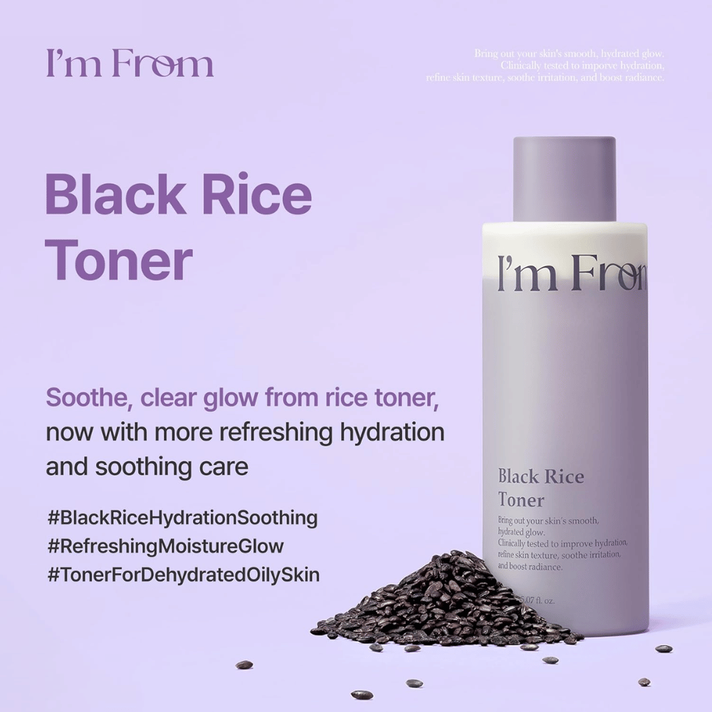 I'm From Black Rice Toner 150 ml mustalla riisillä, kosteuttava kasvovesi lilassa pullossa riisinjyvien kanssa vaaleanlilaa taustaa vasten.