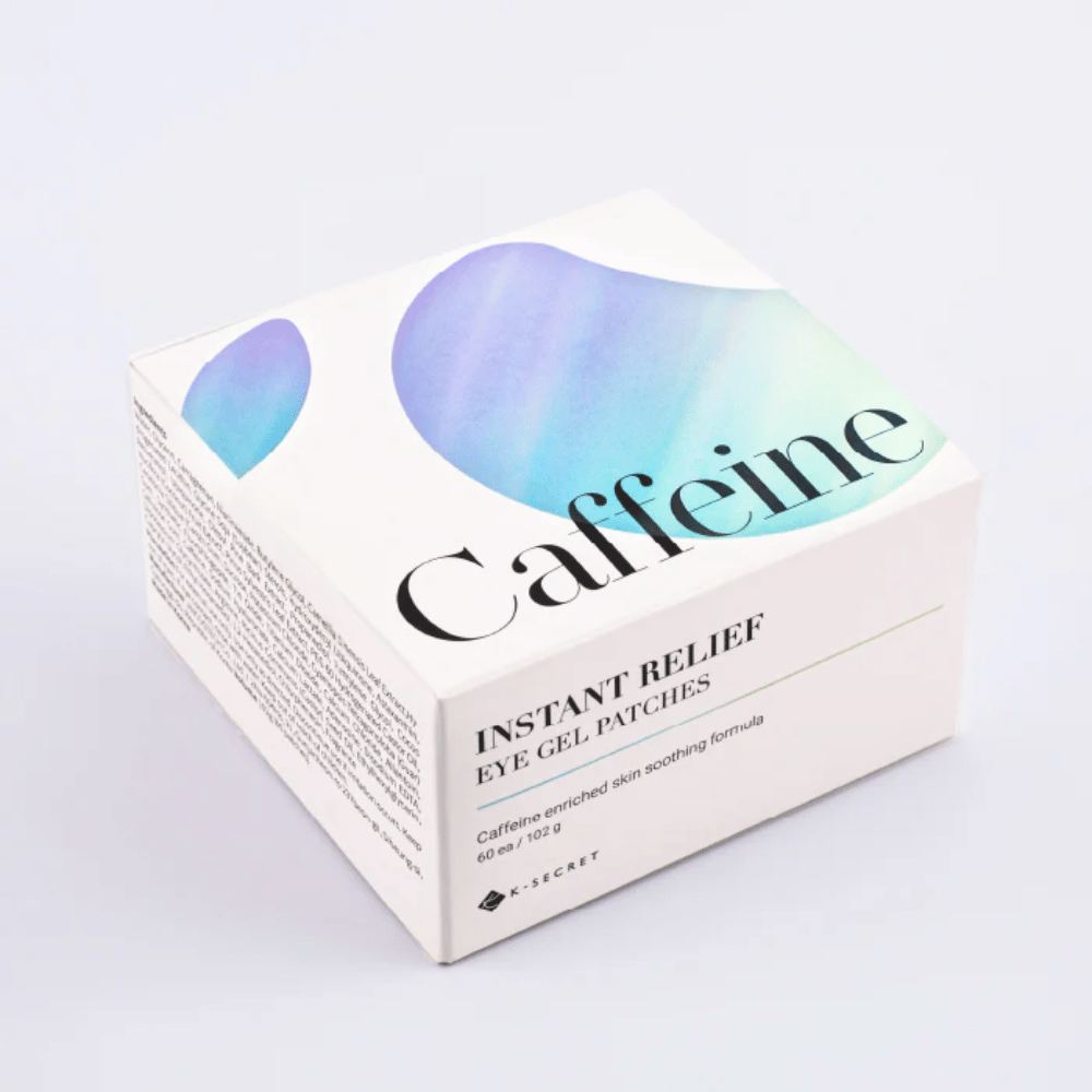 Pakkaus K-Secret Instant Relief Eye Gel Patches kofeiinilla valkoisessa designissa, jossa on sinisiä ja vihreitä sävyjä.