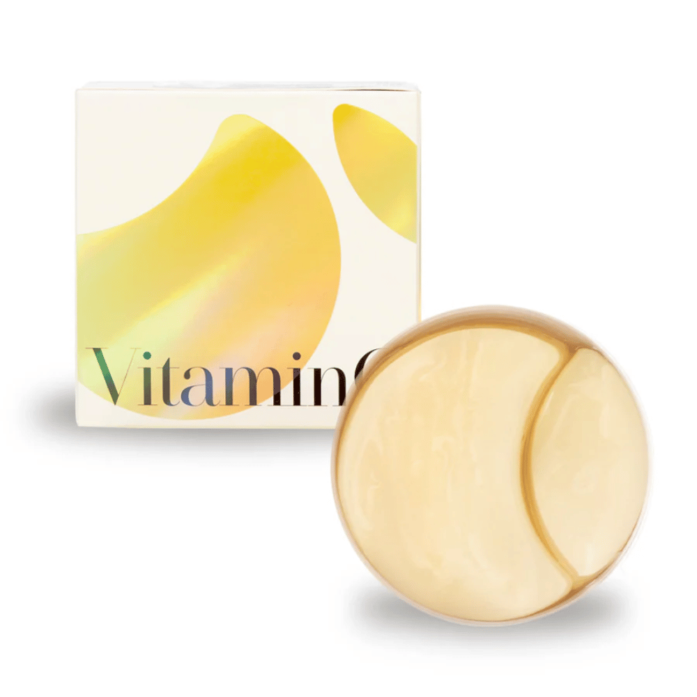 K-Secret Extra Illuminating Eye Gel Patches, jossa on C-vitamiinia kultaisessa hydrogeelissä, purkki ja pakkaus taustalla.