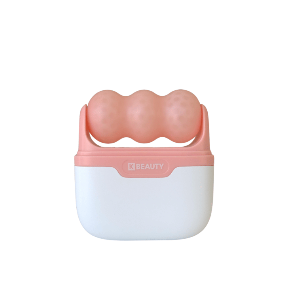 Kuva näyttää K-Beauty Ice Roller valkoisella ja vaaleanpunaisella kahvalla. Tuotteessa on kolme pyöreää, pilkullista rullaa vaaleanpunaisella värillä yläosassa, suunniteltu kasvojen jäähdyttämiseen ja hierontaan. Tausta on täysin valkoinen.