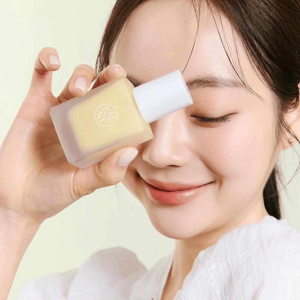 Nainen pitää kädessään pullon KAINE Vita Drop Serum 30ml.