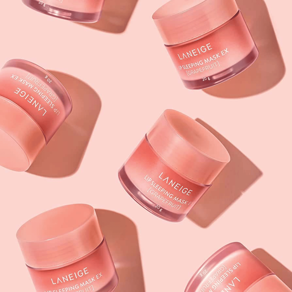 Neljä purkkia LANEIGE Lip Sleeping Mask Greippi 20g vaaleanpunaisella taustalla, edistää greippiä ja kosteutusta.