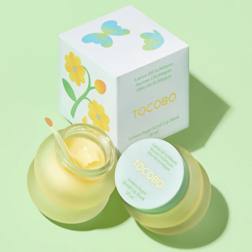 Tocobo Lemon Sugar Scrub Lip Mask yhdessä kukkakuvioisen pakkauksensa kanssa vaaleanvihreällä taustalla.