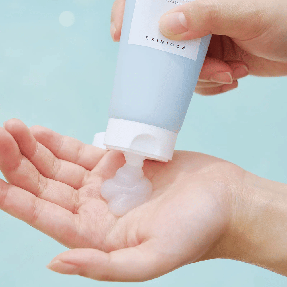 Kuva näyttää jonkun puristavan kirkasta, geelimäistä ainetta tuubista, joka on merkitty "SKIN1004 Madagascar Centella Hyalu-Cica Sleeping Pack" ja sisältää 100 ml tuotetta.