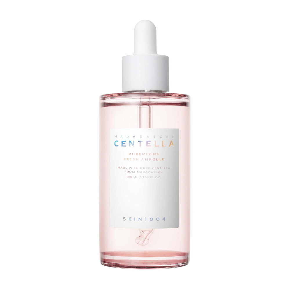 Läpinäkyvä pullo, jossa vaaleanpunaista nestettä ja valkoinen pipetti, SKIN1004 Madagascar Centella Poremizing Fresh Ampoule, valkoisella taustalla.