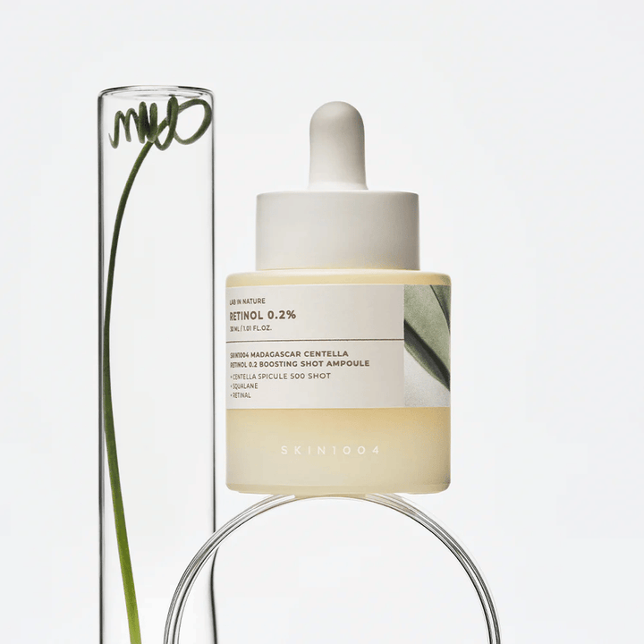 SKIN1004 Madagascar Centella Retinol 0.2 Boosting Shot Ampoule elämäntyylikuvassa kasvielementtien kanssa – kasvoseerumi, joka tukee ihon uusiutumista ja vahvistaa ihon suojakerrosta.