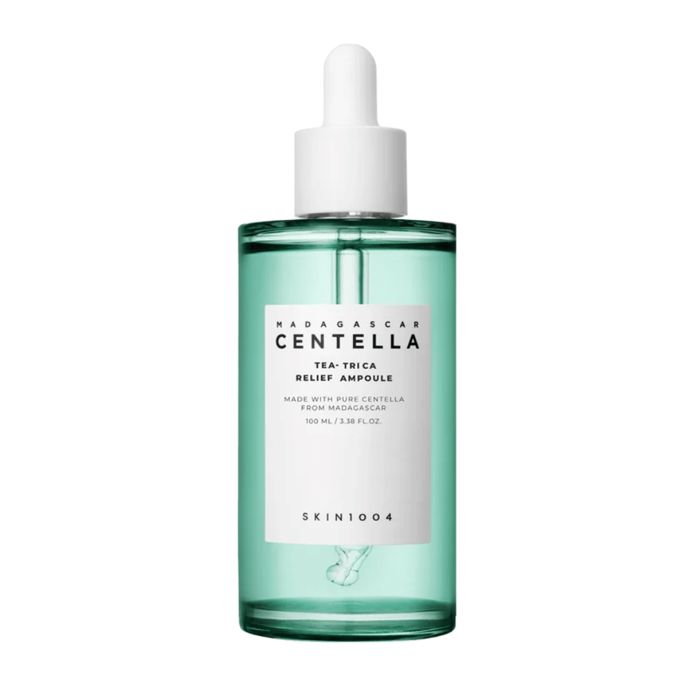 Vihreä läpinäkyvä pullo, jossa on valkoinen etiketti ja pipetti – SKIN1004 Madagascar Centella Tea-Trica Relief Ampoule 100 ml valkoista taustaa vasten.