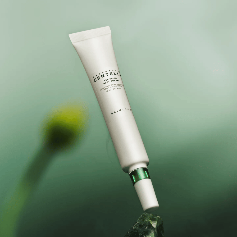 SKIN1004 Madagascar Centella Tea-Trica Spot Cream leijuu vihreää taustaa vasten – tehokas täsmä treatment aknealtteelle iholle Madagaskarin centellalla.