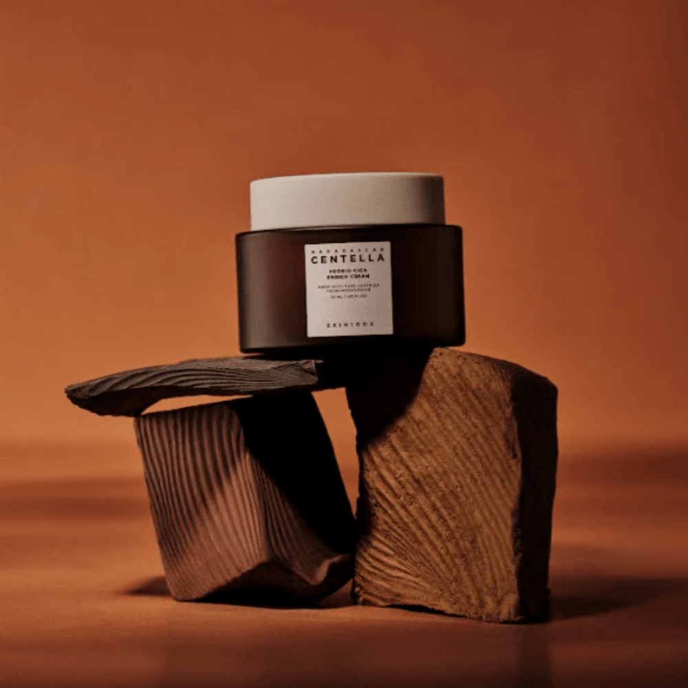 SKIN1004 Madagascar Centella Probio-Cica Enrich Cream tyylikkäässä ruskeassa lasipurkissa koristeellisilla puupalikoilla – ravitseva korealainen kasvovoide, joka vahvistaa ihon suojakerrosta.