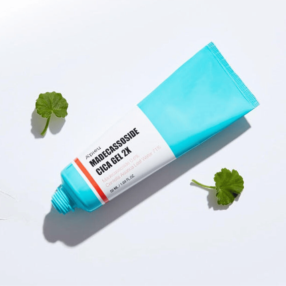 A’pieu Madecassoside Cica Gel 2X sinisessä tuubissa, jossa on valkoinen etiketti, ympäröitynä kolmella vihreällä centella asiatica -lehdellä valkoisella taustalla.