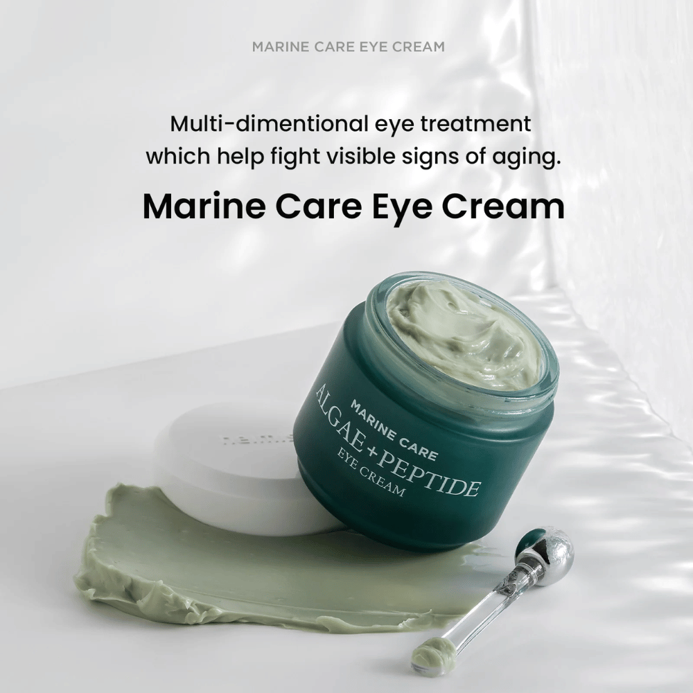 Heimish Marine Care Algae + Peptide Eye Cream avoimessa purkissa, jossa on vihertävää voidetta. Voide on levitetty purkin viereen ja applikaattori on sen vieressä. Tuote taistelee ikääntymisen merkkejä vastaan ja tarjoaa intensiivistä kosteutusta.
