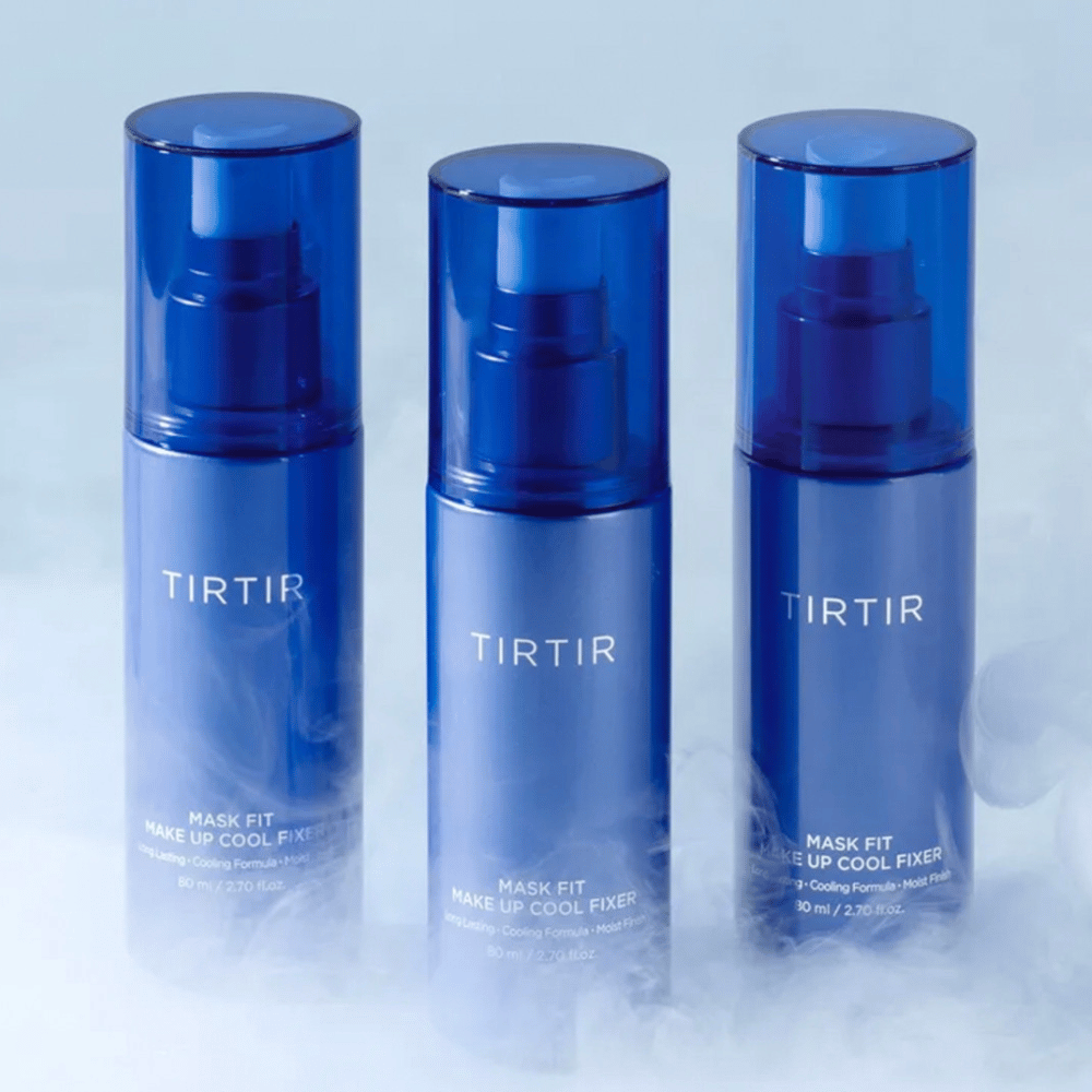 Kolme sinistä spraypulloa, joissa on etiketissä "TIRTIR Mask Fit Make Up Cool Fixer". Jokainen pullo sisältää 80 ml (2,70 fl. oz.) ja on suunniteltu antamaan viilentävä tunne ja pitkäkestoinen meikki. Pullot seisovat vaalealla taustalla, jossa on sumua luomaan raikkauden tunnelmaa.